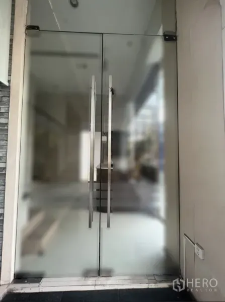 零售空间 出租在Watthana, Bangkok - 店铺入口的磨砂玻璃双开门，配不锈钢把手。