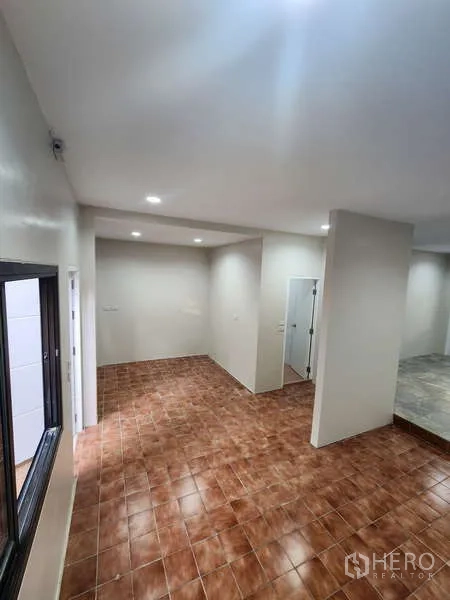 Townhouse for rent in Wang Thonglang, Bangkok - Dining zone with brown floor tiles and window overlooking the front.