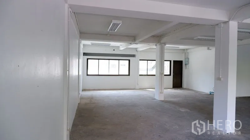 办公空间 出租在Watthana, Bangkok - 开放工作区，可见窗户、天花灯具和室内门。