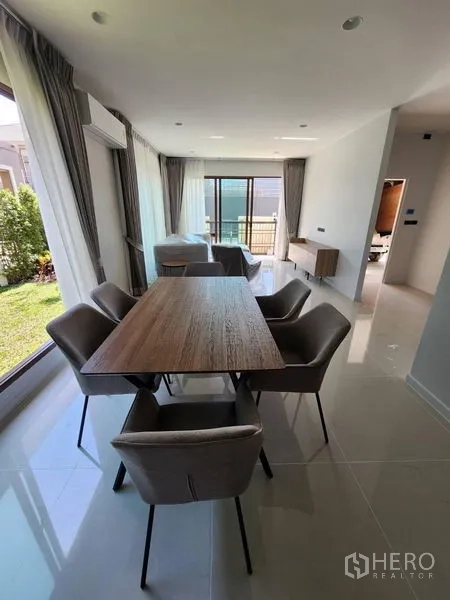 Detached House for rent in Bang Kapi, Bangkok - Dining area for six beside full-height windows overlooking the lawn.