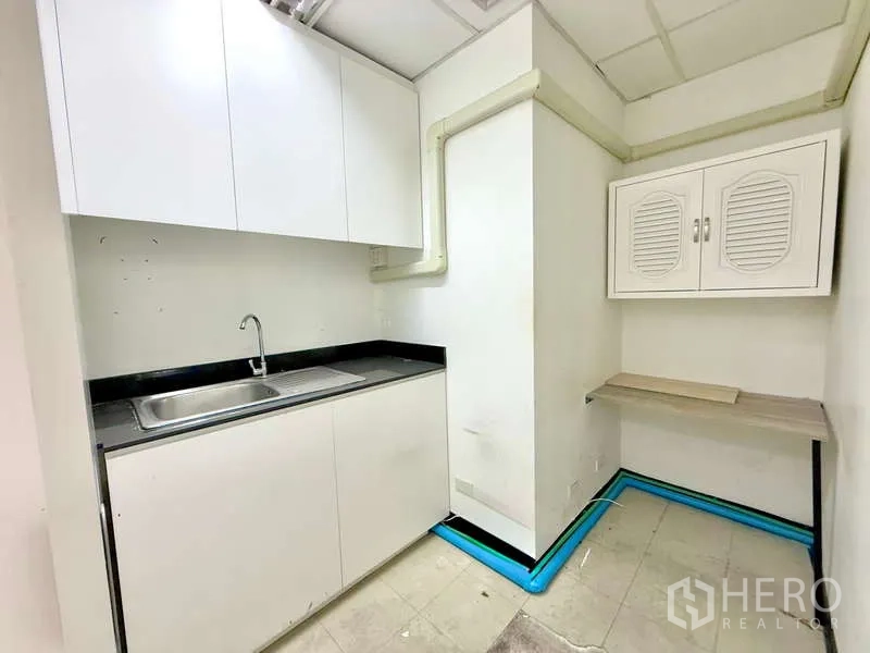 办公空间 出租在Chatuchak, Bangkok - 茶水间，白色橱柜、水槽与黑色台面