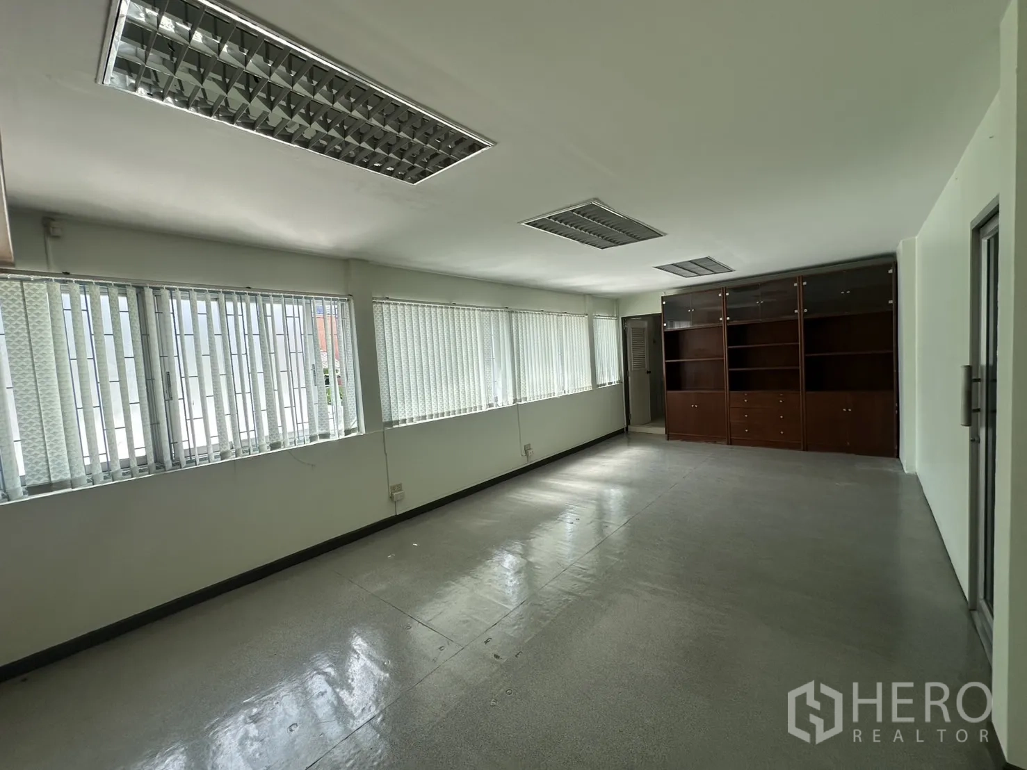 零售空间 出租在Watthana, Bangkok - 修长办公室，窗墙与深色木柜。