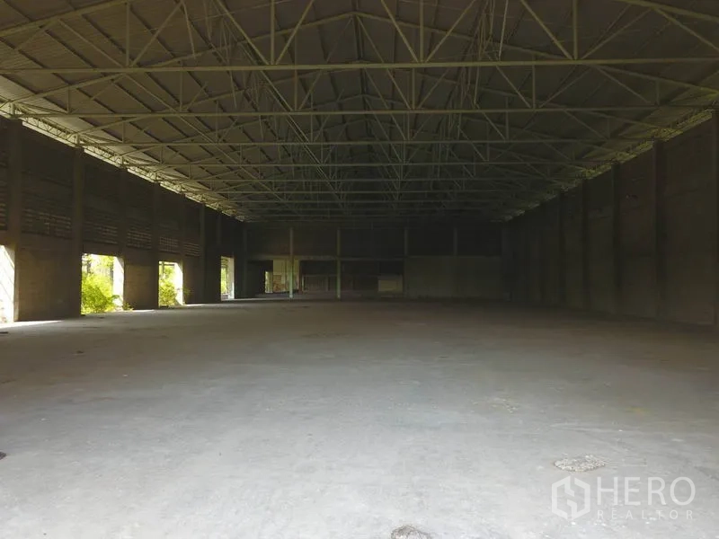 工厂 出售在Samut Prakan - 宽阔空置仓库内景，挑高天花与多处采光开口