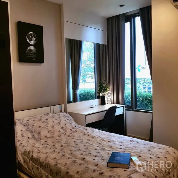 Condominium for rent in Sathon, Bangkok - Bedroom with single bed, large mirror, workstation and tall windows.