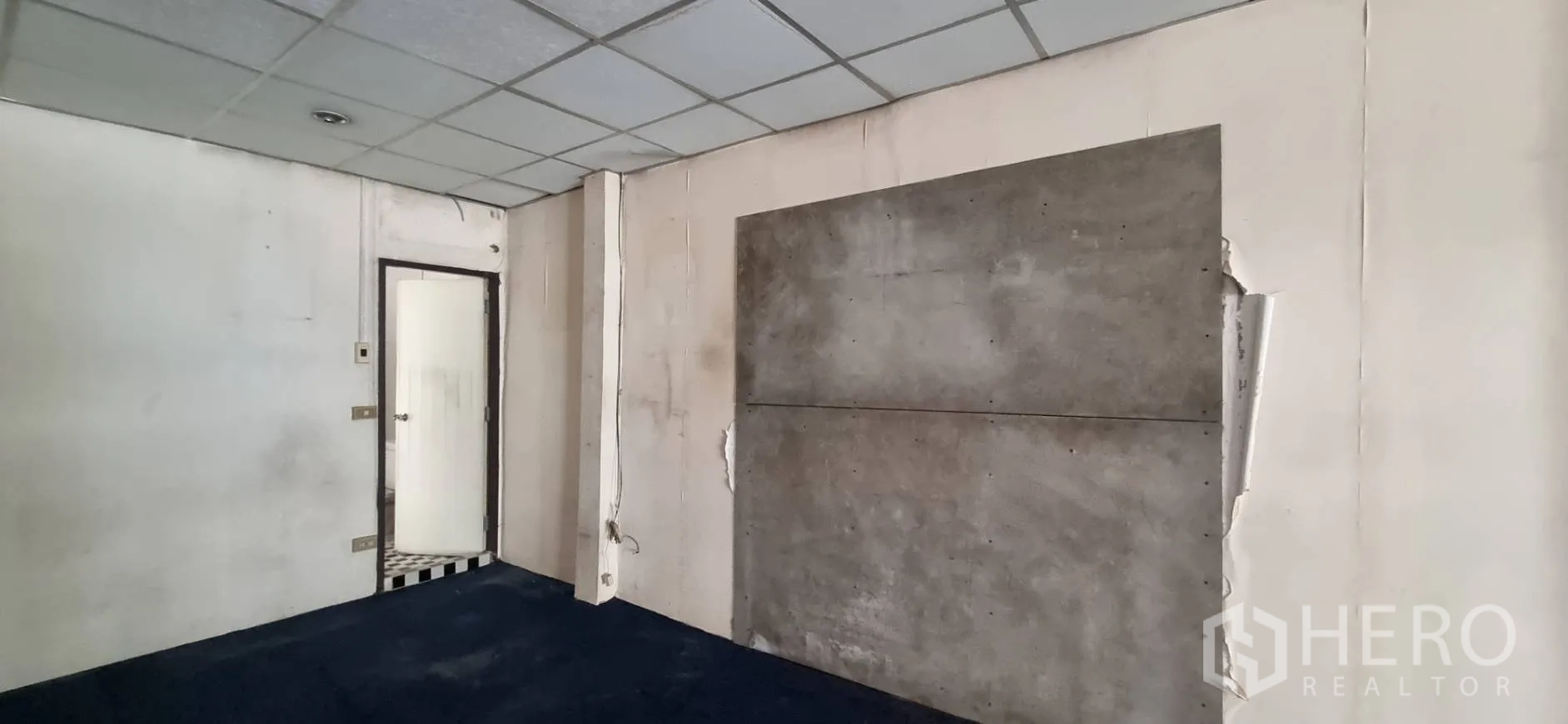 店屋 出租或出售在Bangkok - 楼层一角，通往浴室的门与混凝土装饰墙。
