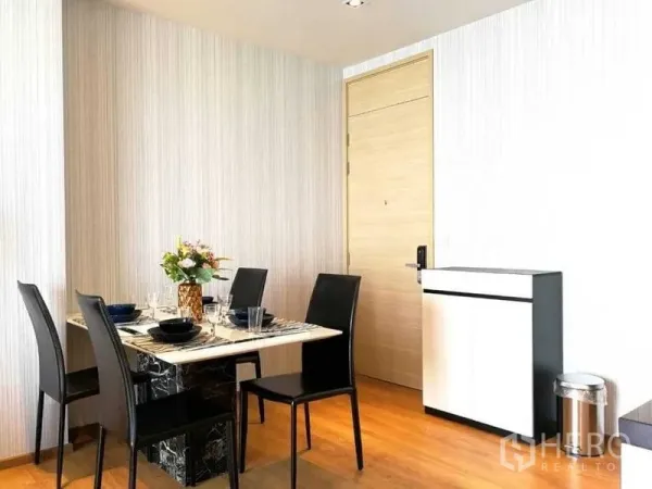 คอนโด ให้เช่า - มุมรับประทานอาหารสว่าง โต๊ะท็อปหินอ่อน เก้าอี้สีดำ 4 ตัว และพื้นลามิเนตลายไม้