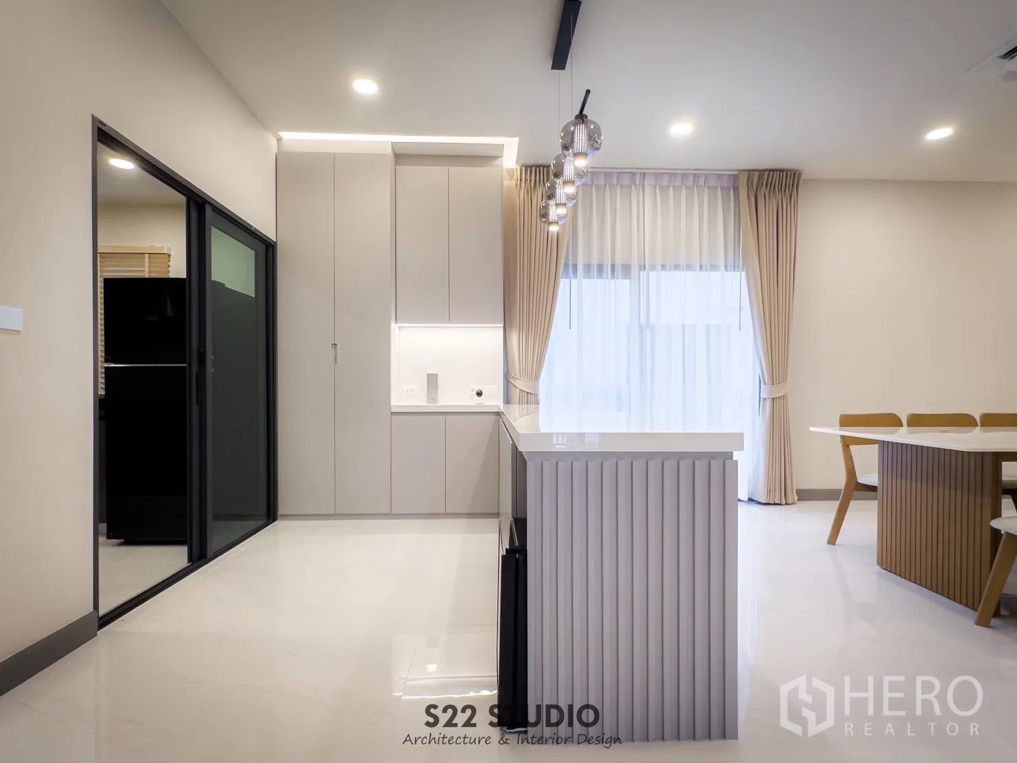 Detached House for rent in Bang Phli, Samut Prakan - Kitchen island and tall cabinets next to a sliding door leading to the enclosed Thai kitchen.