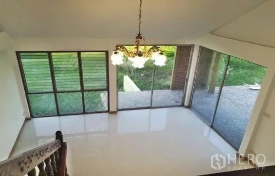 办公空间 出租在Chatuchak, Bangkok - 挑高大堂，吊灯与落地窗，面向草坪花园。