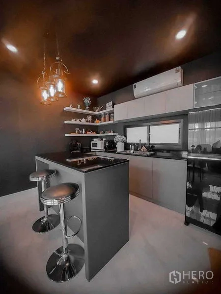 Detached House for rent in Bang Bo, Samut Prakan - Modern kitchen with island, bar stools, open shelving and pendant lights.