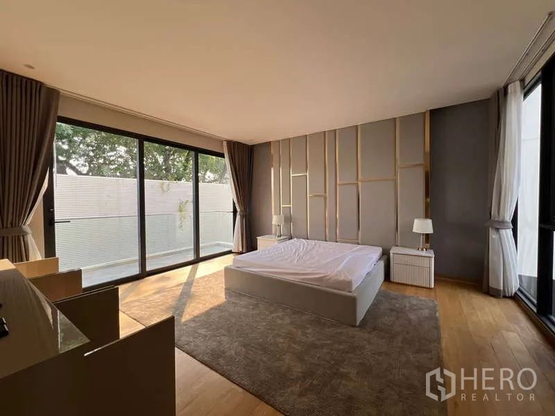 独立式住宅 出租在Suan Luang, Bangkok - 宽敞主卧，木地板与全高玻璃门
