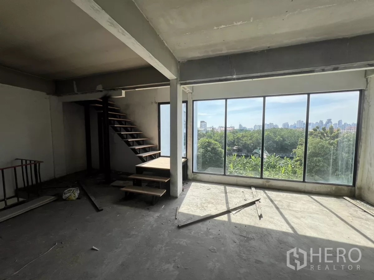 店屋 出售在Suan Luang, Bangkok - 高层空间，通过整面玻璃可见树梢与城市天际线。