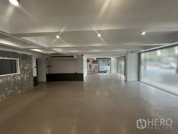 零售空间 出租在Bang Rak, Bangkok - 采光充足的店铺，嵌灯照明，宽幅玻璃面向人行道，后方为服务区。