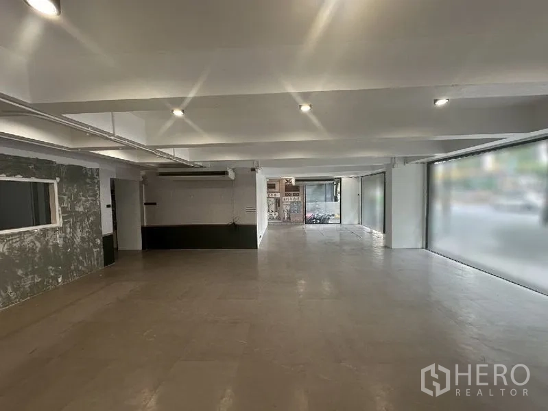 零售空间 出租在Bang Rak, Bangkok - 采光充足的店铺，嵌灯照明，宽幅玻璃面向人行道，后方为服务区。