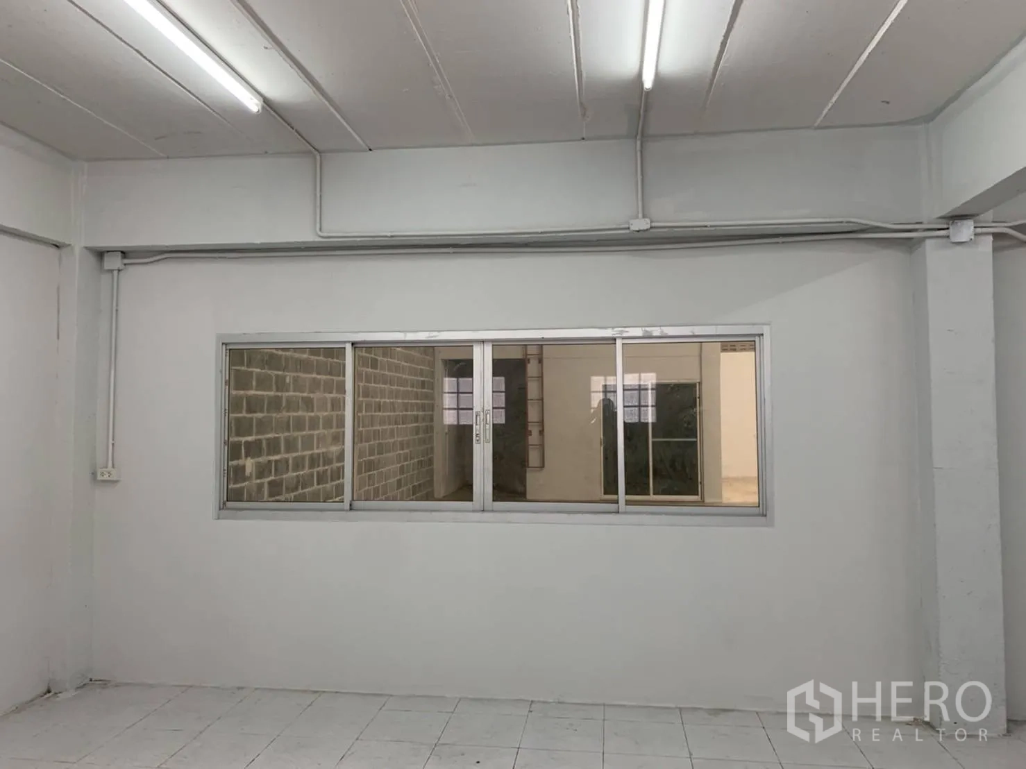 Warehouse for rent in Khlong Sam Wa, Bangkok - Internal office with sliding window looking onto the warehouse floor.