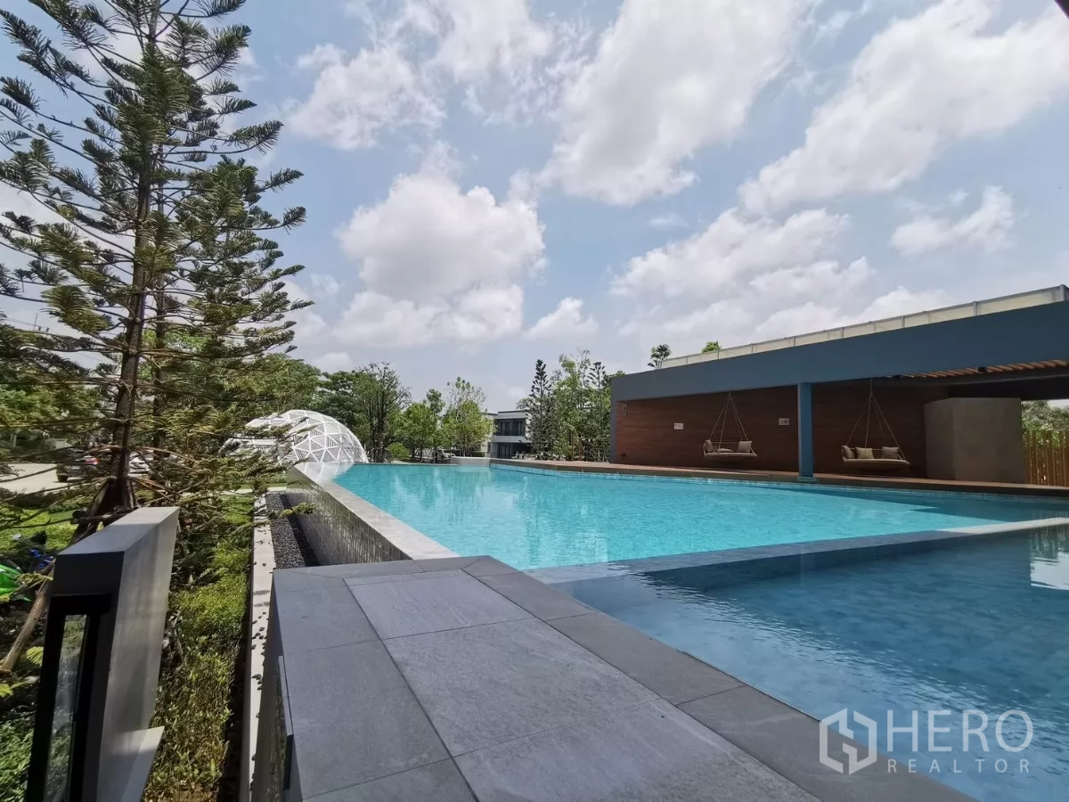 Detached House for rent in Bang Phli, Samut Prakan - Large outdoor swimming pool with pavilion seating at the community clubhouse.