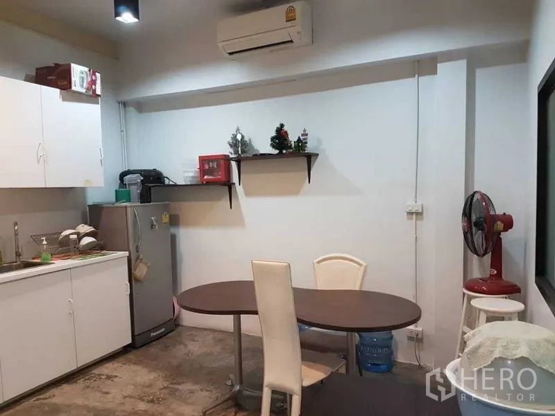 店屋 出售在Bang Rak, Bangkok - 简约茶水间，白色橱柜、冰箱与椭圆餐桌，适合作为办公配套。