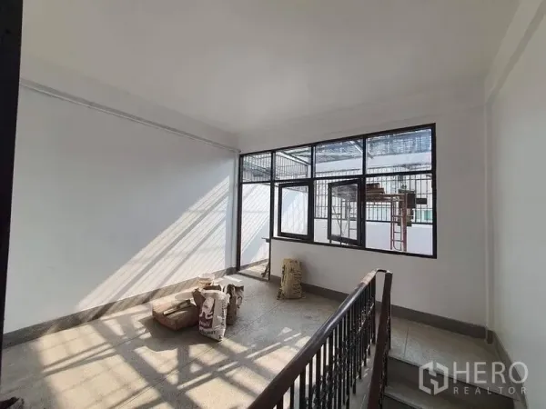 อาคารพาณิชย์ ให้เช่าในBangkok - โถงชั้นบนพร้อมราวบันไดโลหะและหน้าต่างเหล็กดัดบานกว้าง แสงธรรมชาติส่องถึง