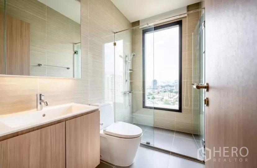 คอนโด ให้เช่าในChatuchak, Bangkok - ห้องน้ำสมัยใหม่ พร้อมตู้กระจกกั้นอาบน้ำและหน้าต่างมองเห็นวิวเมือง.