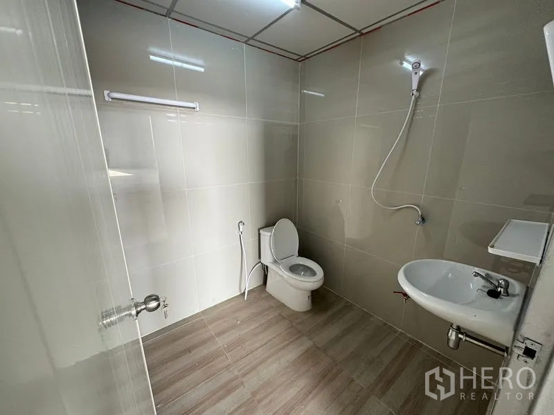 货栈 出租在Lam Luk Ka, Pathum Thani - 整洁的瓷砖卫生间，配坐便器、洗手盆和淋浴。