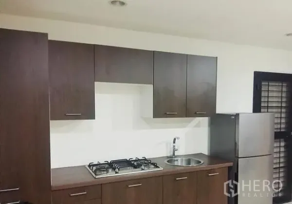 บ้าน ให้เช่าในChok Chai, Nakhon Ratchasima - ครัวบิวท์อินตู้ไม้สีเข้ม เตาแก๊ส ซิงก์กลม และตู้เย็นสแตนเลส