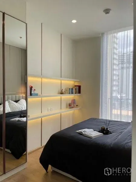 公寓 出售在Watthana, Bangkok - 明亮卧室，带发光置物架、镜面衣柜与落地窗。