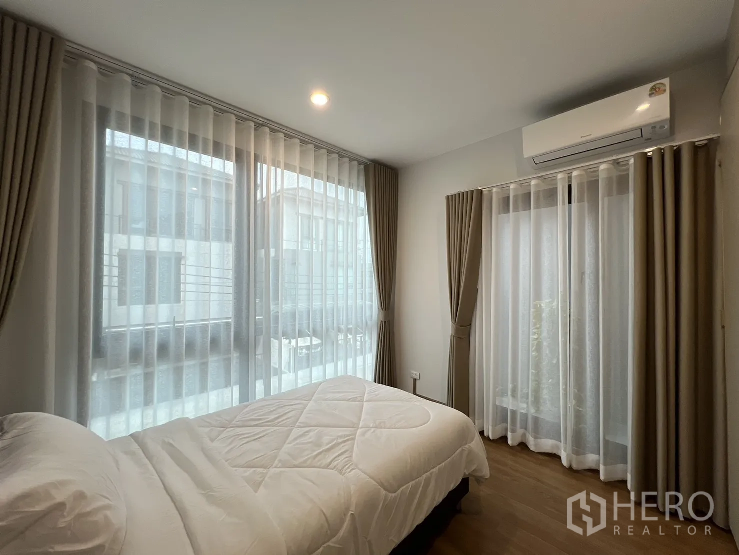 Detached House for rent in Prawet, Bangkok - Corner single bedroom with large windows and sheer curtains.