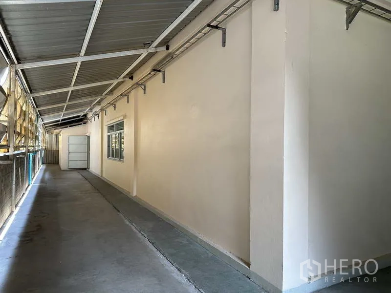 工厂 出租在Samut Prakan - 厂房侧边带顶服务走道，金属屋面与电缆桥架。