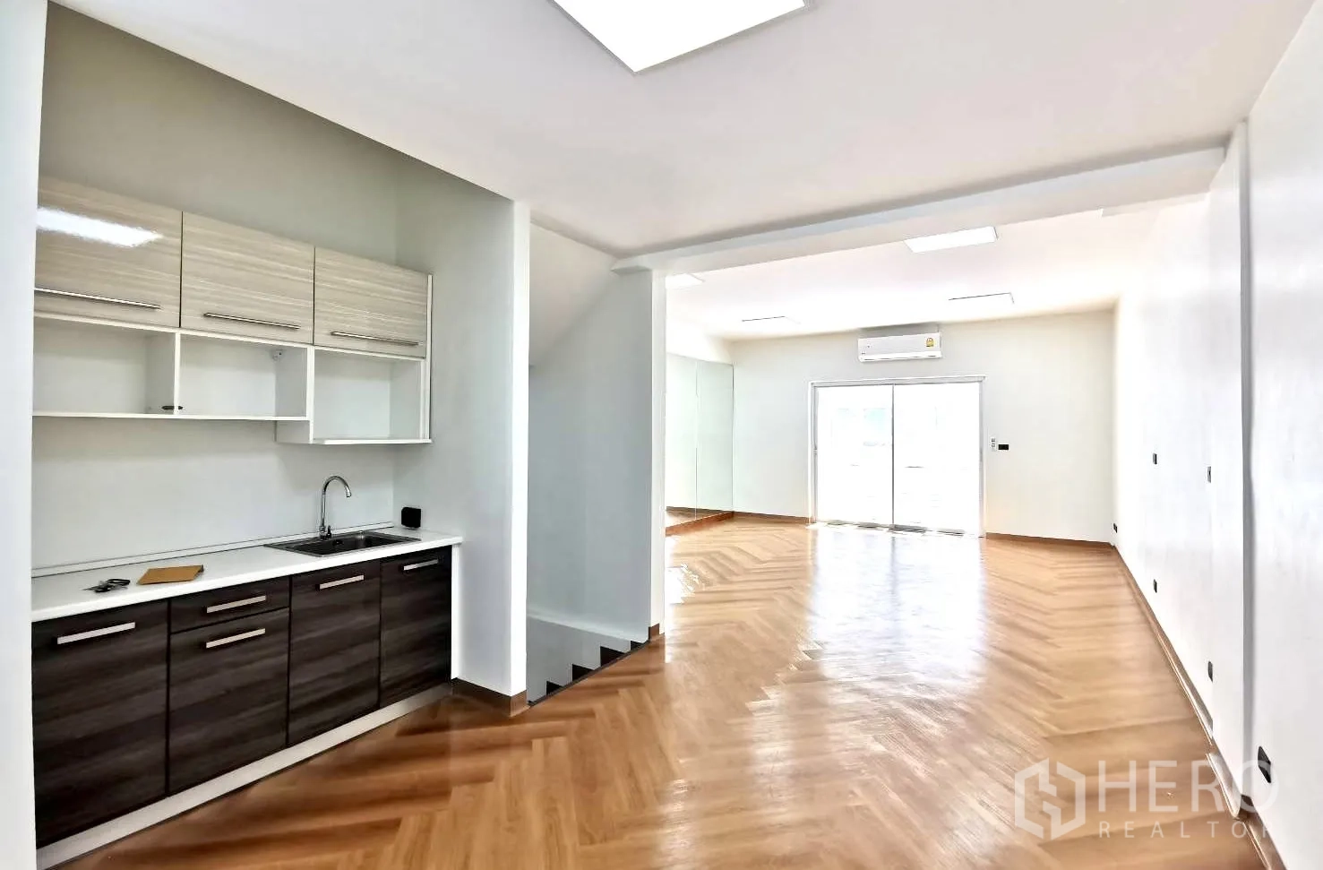 Home Office for rent in Watthana, Bangkok - Built-in pantry with upper cabinets and sink beside an open workspace with natural light.