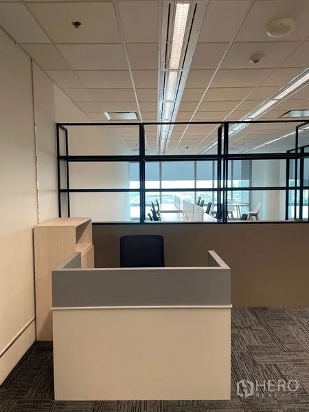 Office Space for rent in Dusit, Bangkok - Reception desk facing a black-framed glass partition and bright open workspace.