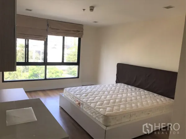 คอนโด ให้เช่าหรือขายในWatthana, Bangkok - ห้องนอนกว้างมีหน้าต่างมุมขนาดใหญ่ ผ้าม่านโรมัน และเตียงบนพื้นไม้.