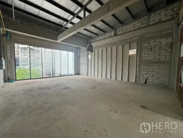 พื้นที่ขายปลีก ให้เช่า - พื้นที่เพดานสูง โครงเหล็ก โคมไฟห้อย และผนังกระจกบานเลื่อนรับแสง