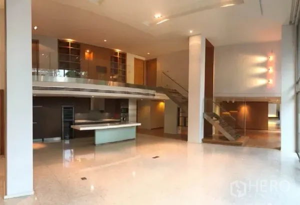 คอนโด ขายในKhlong Toei, Bangkok - ห้องนั่งเล่นเพดานสูงสองชั้น พร้อมชั้นลอย บันไดกระจก และครัวแบบเปิดมีไอส์แลนด์