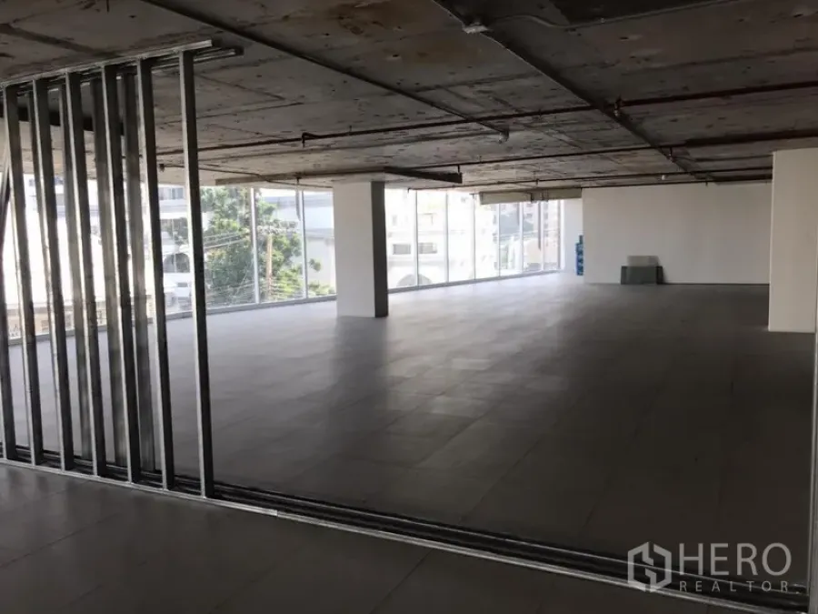 办公空间 出租在Khlong Toei, Bangkok - 未完成装修的办公室，金属龙骨隔墙、外露设备与整面玻璃立面。