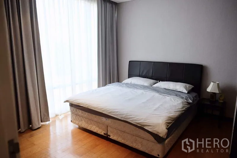 Condominium for rent in Watthana, Bangkok - Guest bedroom with double bed, bedside table and sheer floor-to-ceiling curtains.
