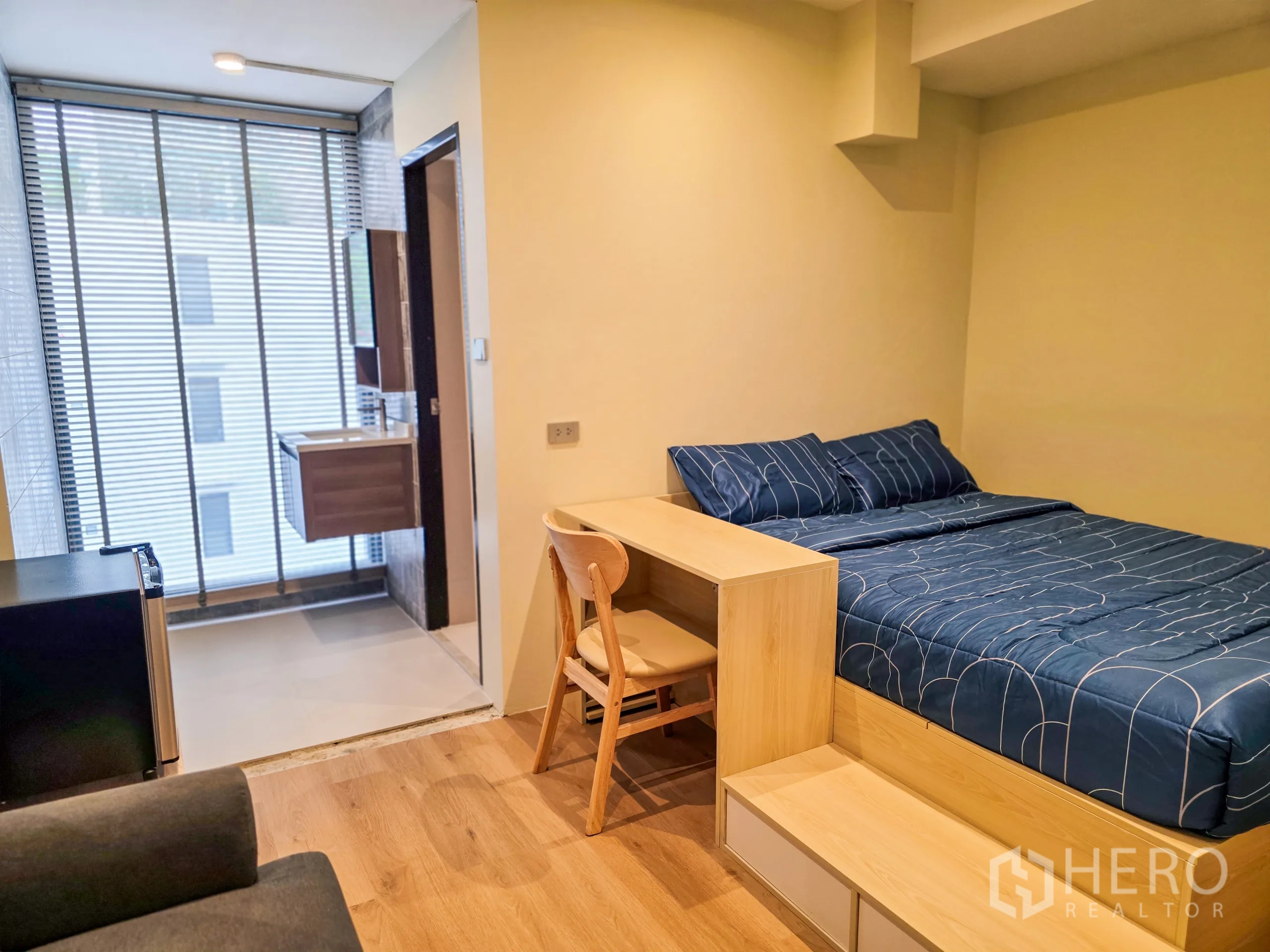 อาคารพาณิชย์ ให้เช่าในWatthana, Bangkok - ห้องนอนผ้าปูสีน้ำเงิน โต๊ะทำงาน และมู่ลี่เชื่อมห้องน้ำ