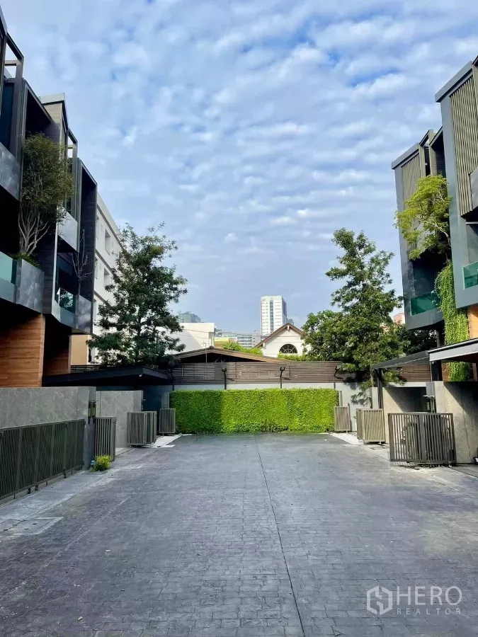 ทาวน์เฮาส์ ให้เช่าในChatuchak, Bangkok - ถนนส่วนกลางของโครงการระหว่างทาวน์โฮมหรู โทนดำไม้ พร้อมต้นไม้และท้องฟ้าโปร่ง