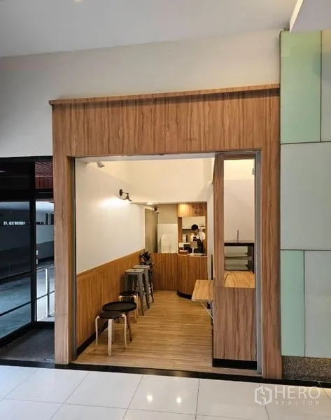 零售空间 出租在Watthana, Bangkok - 木质装饰的小型零售店铺，带服务吧台、座椅和展示柜，位于大楼大堂