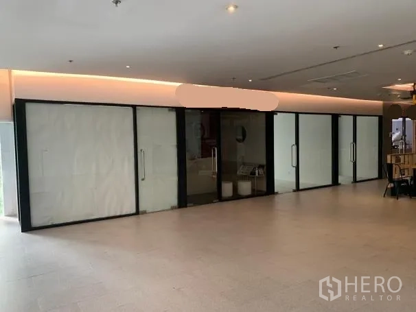 พื้นที่ขายปลีก ให้เช่า - หน้าร้านกระจกกว้างของร้านค้าในอินดอร์พลาซ่าข้างโซนที่นั่ง