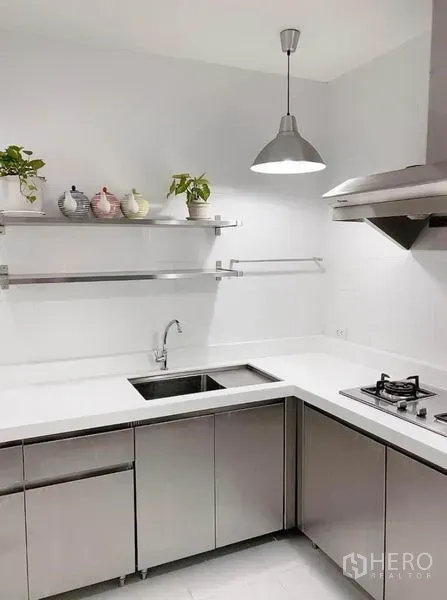ทาวน์เฮาส์ ให้เช่าในPrawet, Bangkok - ครัวรูปตัวแอล เคาน์เตอร์สีขาว ตู้สแตนเลส เตาแก๊ส เครื่องดูดควันและอ่างล้างจาน ใต้โคมไฟแขวน