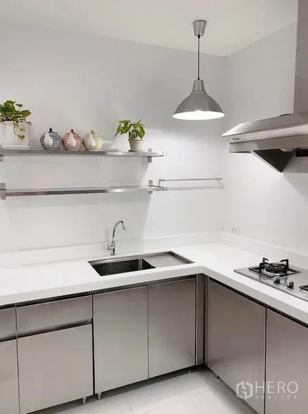 ทาวน์เฮาส์ ให้เช่าในPrawet, Bangkok - ครัวรูปตัวแอล เคาน์เตอร์สีขาว ตู้สแตนเลส เตาแก๊ส เครื่องดูดควันและอ่างล้างจาน ใต้โคมไฟแขวน