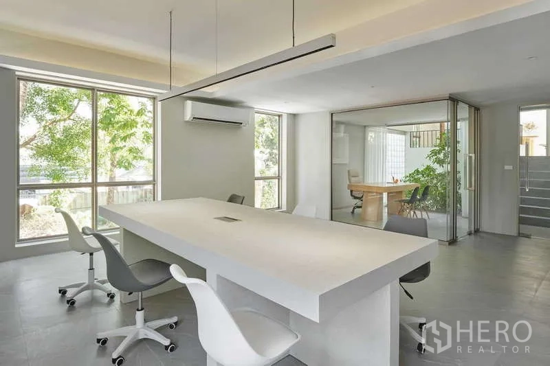Home Office for sale in Chatuchak, Bangkok - Open office with long table, sliding glass partition to manager room and garden views.
