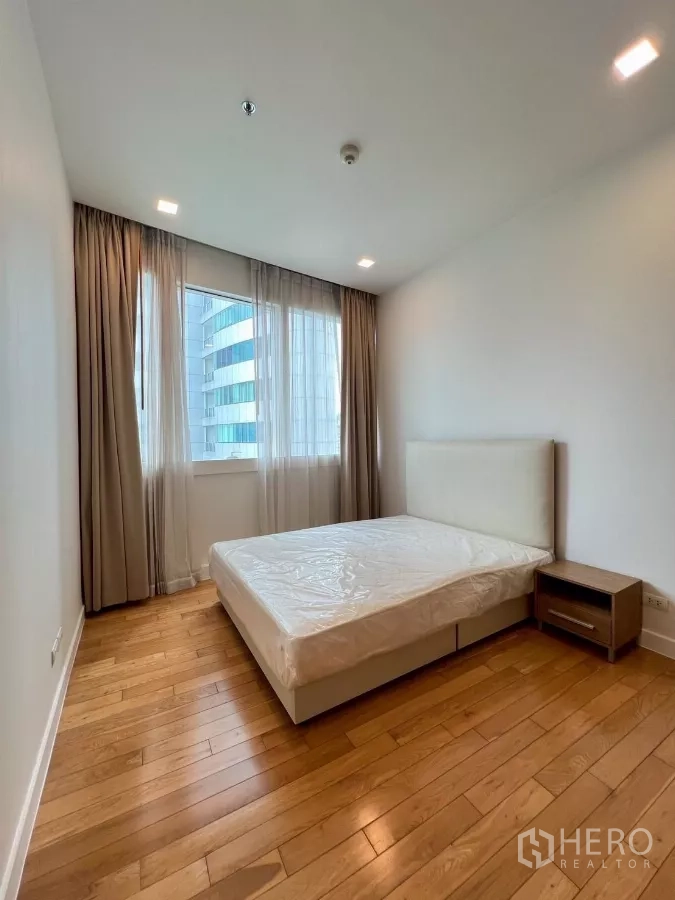 公寓 出租在Khlong Toei, Bangkok - 第二卧室，双人床、床头柜与城市景观窗户。