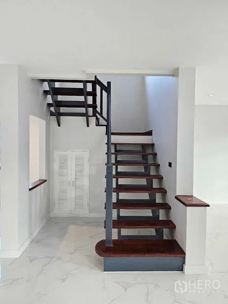Detached House for sale in Thanyaburi, Pathum Thani - Open-tread staircase with metal railing and storage cabinet underneath.