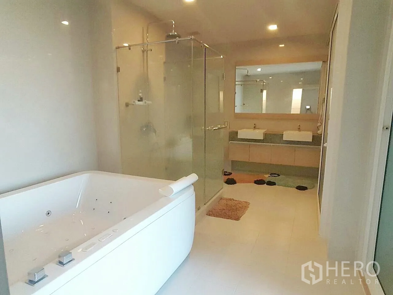 Condominium for sale in Khan Na Yao, Bangkok - Spacious bathroom with jacuzzi tub, glass shower and double vanity.