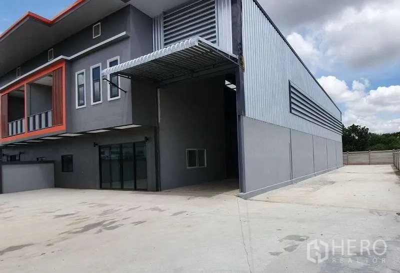 货栈 出租在Pathum Thani - 侧立面带有遮雨装卸口、金属墙板和宽阔车道