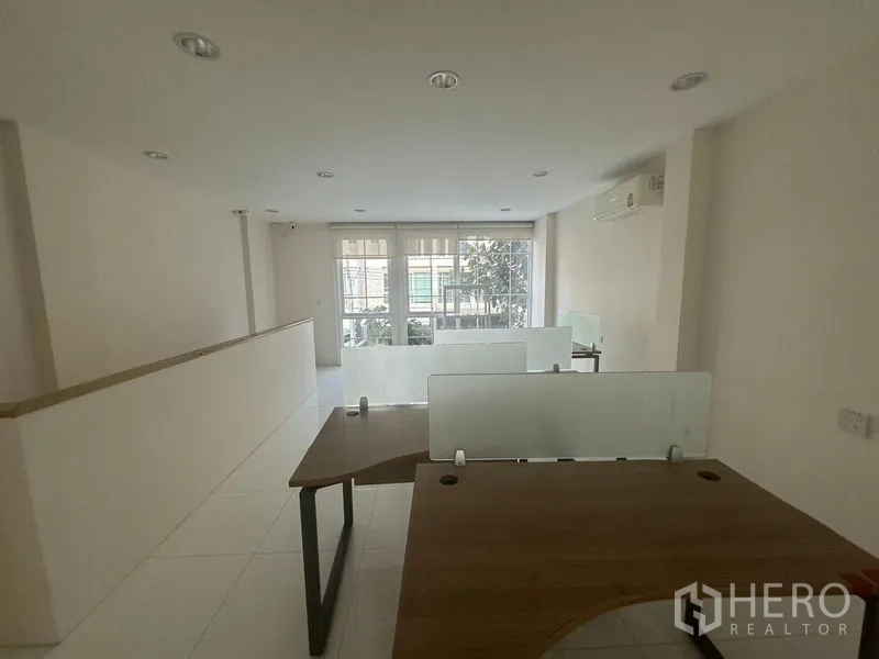 带办公室的家 出租在Bang Na, Bangkok - 工位区另一视角，展示多张办公桌与窗户。