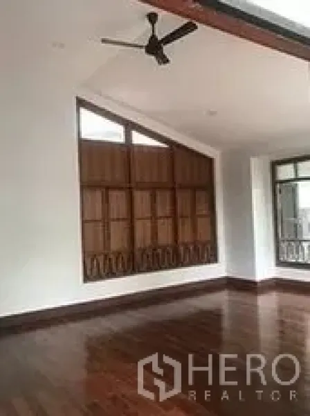 零售空间 出租在Bangkok - 明亮的零售室内空间，抛光木地板、吊扇与大面积窗户。