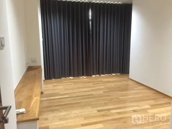 คอนโด for ในWatthana, Bangkok - ห้องนอนพร้อมผ้าม่านทึบแสงสีเข้ม พื้นไม้ และที่นั่งริมหน้าต่างแบบบิลท์อิน