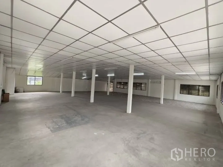Warehouse for rent in Prawet, Bangkok - Large upper-floor hall with tiled drop ceiling, columns, and multiple windows.