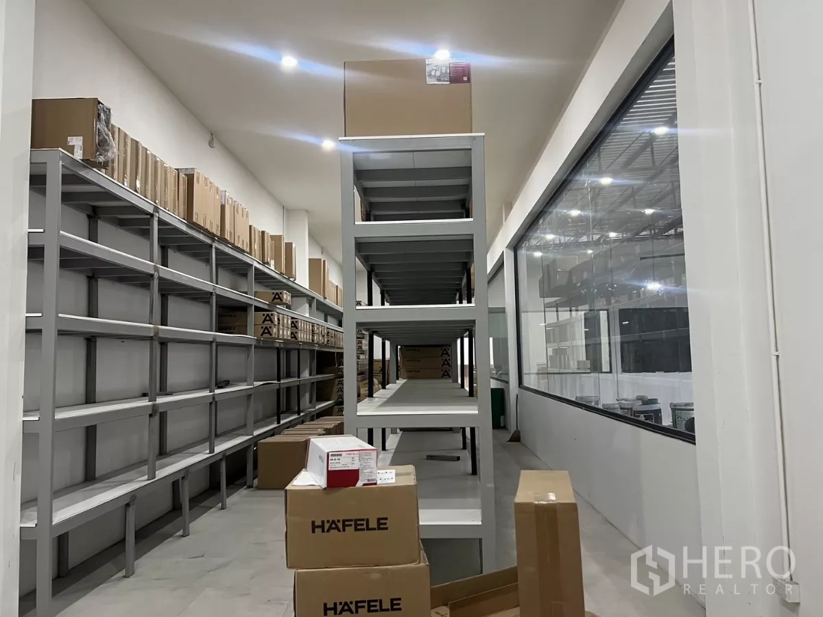 คลังสินค้า ให้เช่าหรือขายในLat Krabang, Bangkok - ทางเดินชั้นวางเหล็กและกล่องสินค้า ข้างหน้าต่างกระจกบานใหญ่